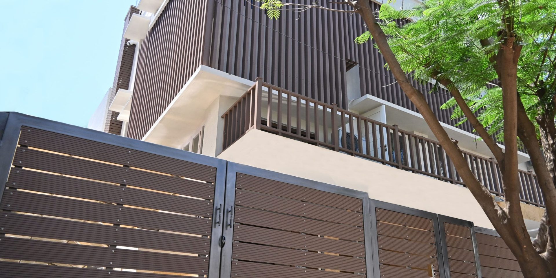 Designer gates and railings with modern vertical cladding on a building.